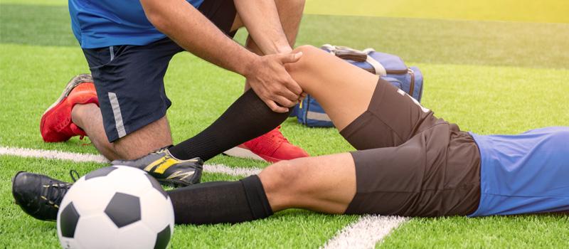 Soccer Player Laying On Field With Injured Knee